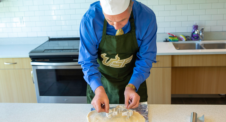 Dean Besterfield holds the cookie cutter above the dough