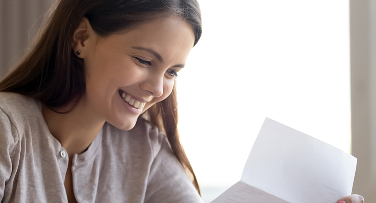 Female student smiling as she considers financial fit in choosing her college and budgeting properly.