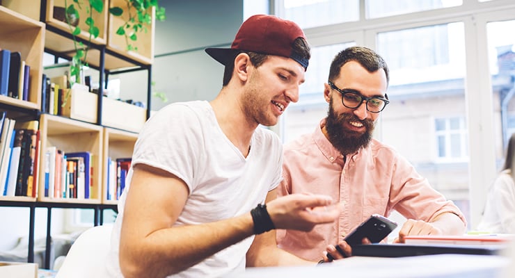 Nontraditional students studying college tips on their phone.