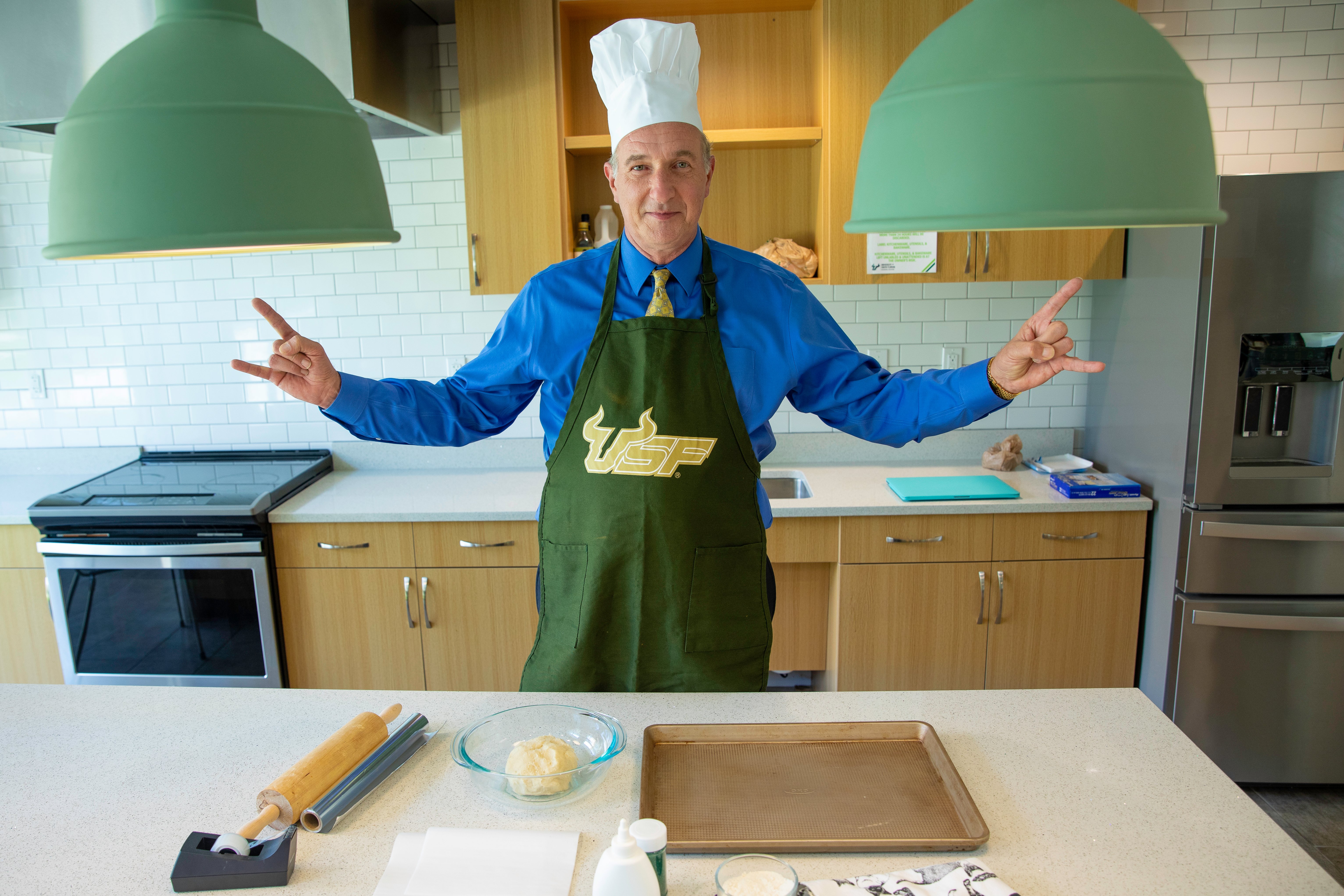 Dean Besterfield gives the "Go Bulls!" hand sign in a kitchen