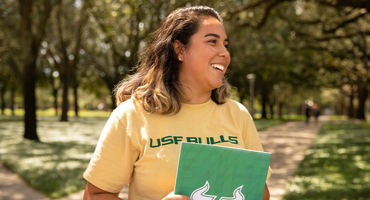 First generation student at USF walking around campus.