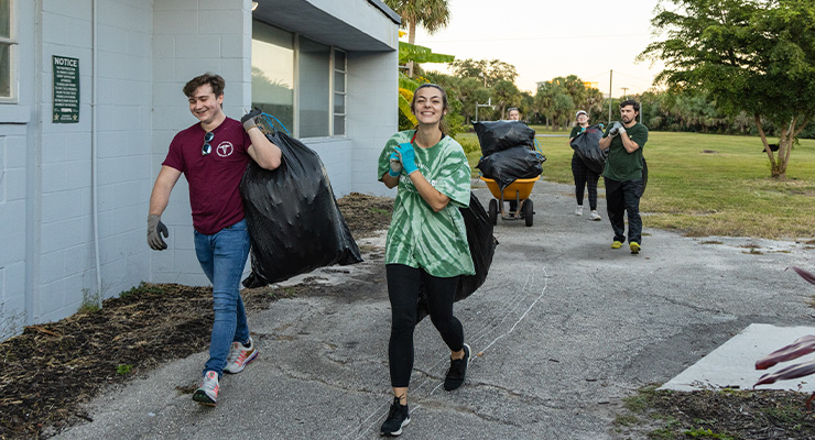 Students carrying trash bags on Earth Day.
