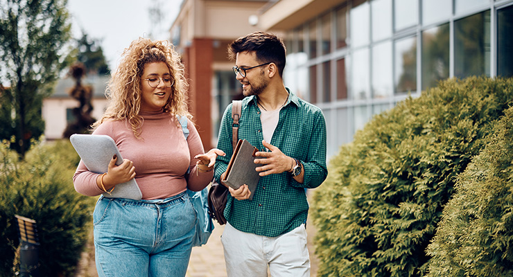 Two friends walking together on campus.