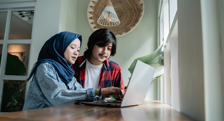 Two students using a laptop.