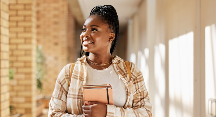 A female student walking and smiling after getting into her dream college.