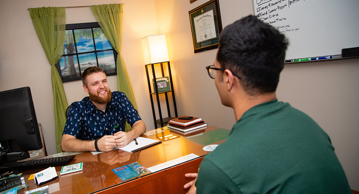 Student meeting with his advisor discussing the reasons to finish high school strong.