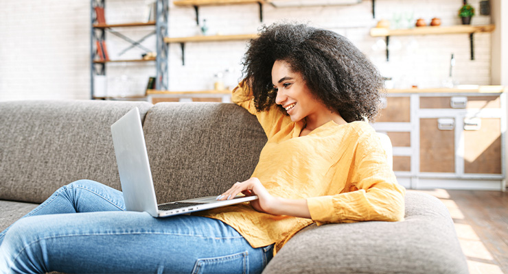 Female student using her laptop to research ways to cut college costs.