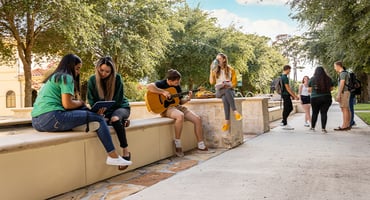 A group of USF students spending time outside on campus.