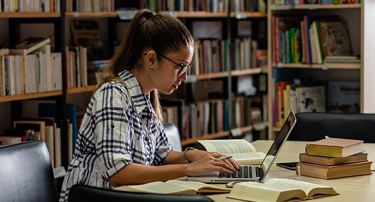 A female transfer student studying in a library.