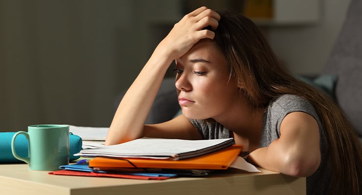 Student with anxiety looking over books.