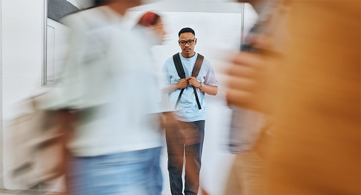 Student walking anxiously among other college students.