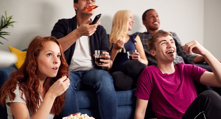 A group of students hanging out and watching TV.
