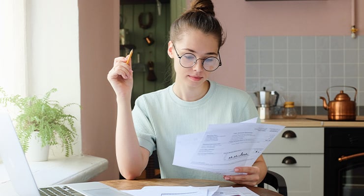 A student taking notes on her financial aid award offer.