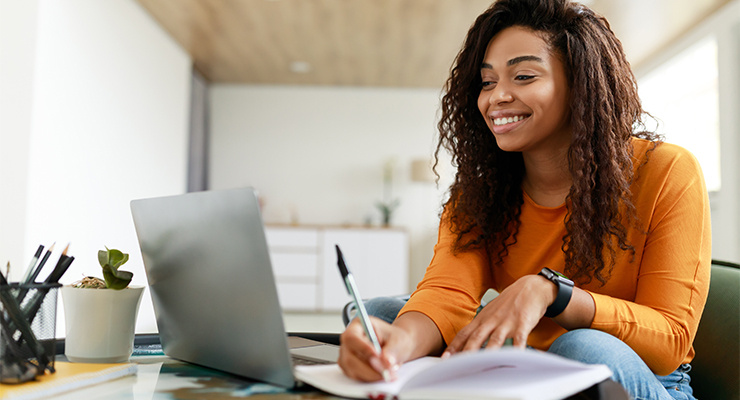 A student smiling while taking notes.