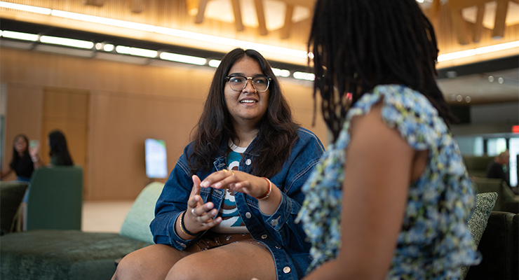 Two honor students having a conversation in the Judy Genshaft Honors College building.