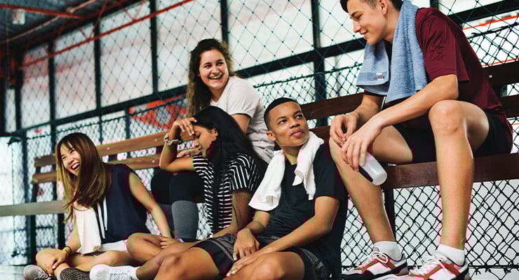 Students laughing while sitting on bleachers together.