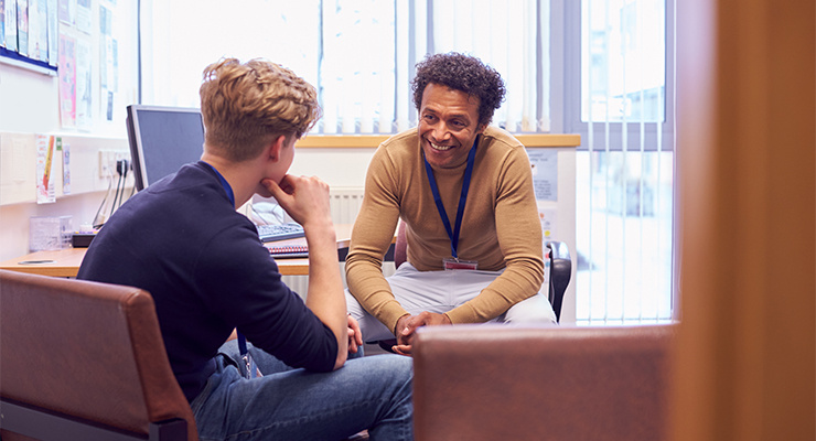 A student speaking with his counselor.