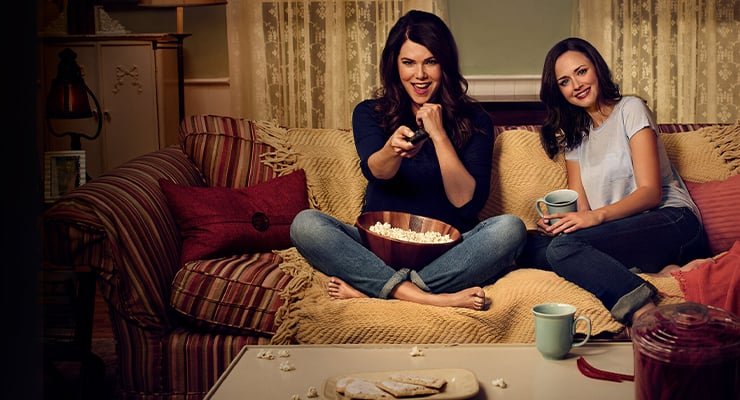 Lorelai Gilmore and Rory Gilmore sitting on a couch.