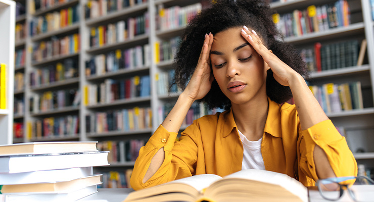 A student reading a book in a library.