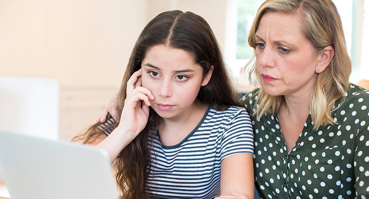 A mother and daughter searching up how to avoid college scholarships scams.