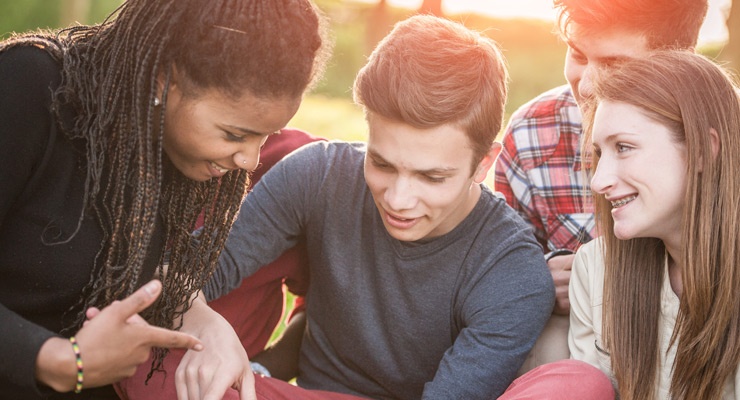 Four high school students talking together. 