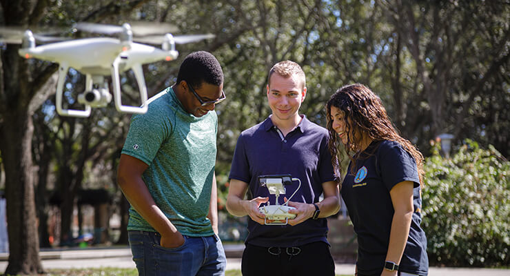 National Merit Scholars at USF participating in research using a drone.