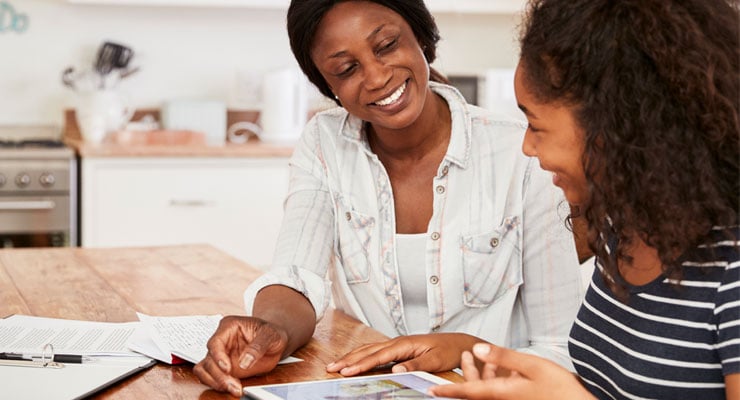 A mother and daughter review summer jobs on a tablet.