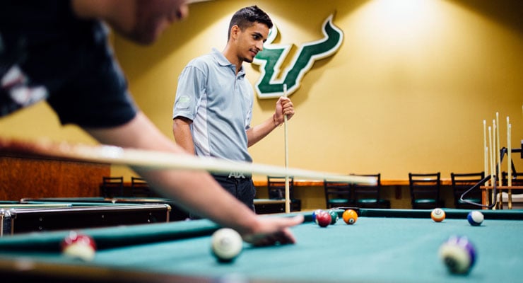 USF students playing a friendly game of pool.