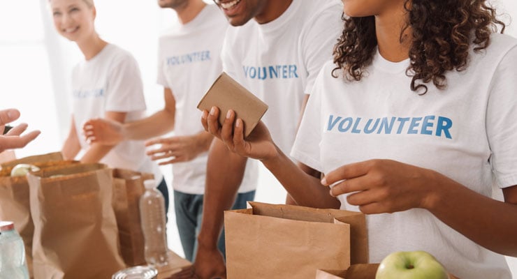 A group of college students making brown bag lunches