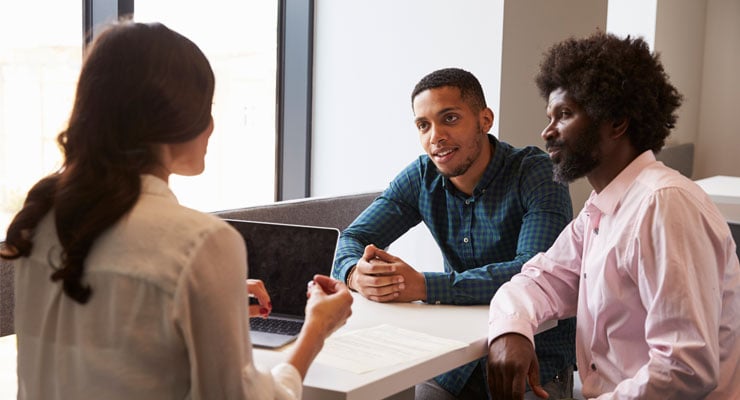 Father and son talking to a counselor about community college options