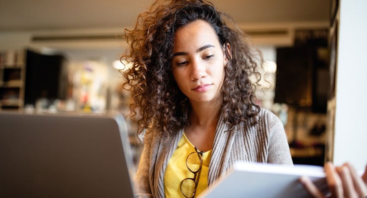 female student in a yellow shirt studies in the library