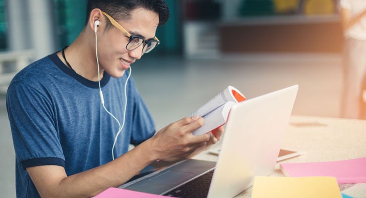 asian american student makes studying fun by listening to music on headphones