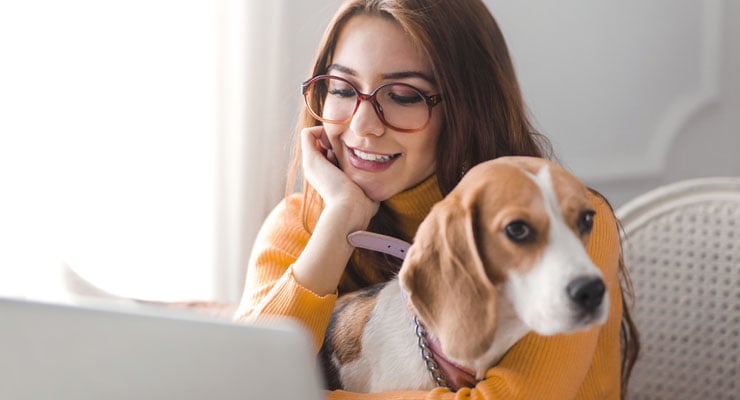female student manages time effectively by studying with her dog