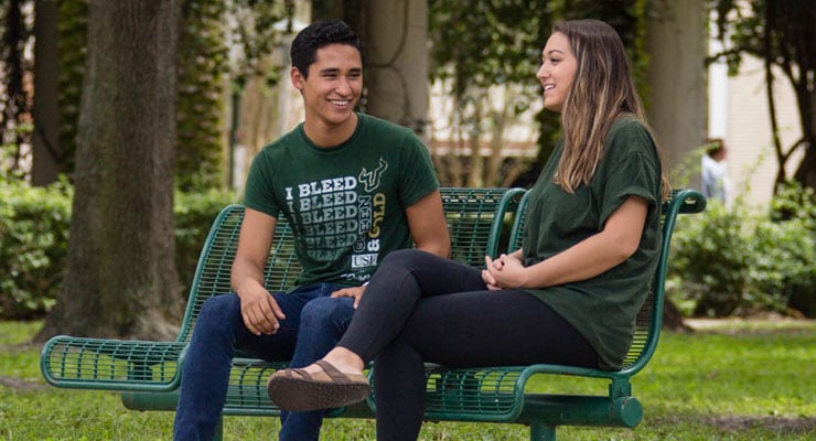 USF students sitting on a bench and talking