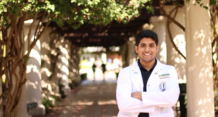 USF student standing outside near the MLK Plaza and the Marshall Student Center