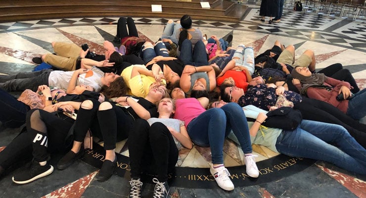 Students lay on a decorative floor during a study abroad trip