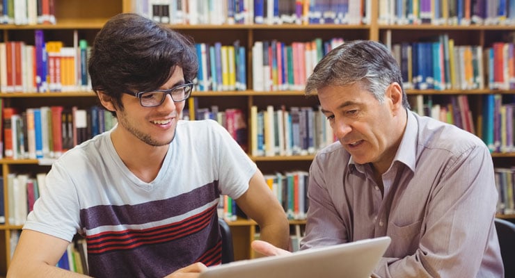 High school student reviewing a college essay with a teacher