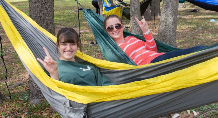 USF students relaxing in hammocks outside on campus.