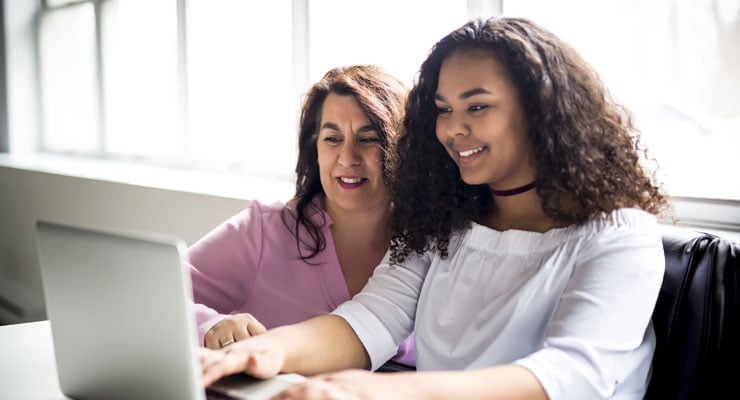 High school student and parent reviewing grants and scholarships online.