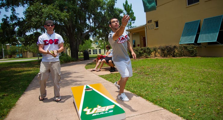 USF students play a game of corn hole outside of Greek Village.