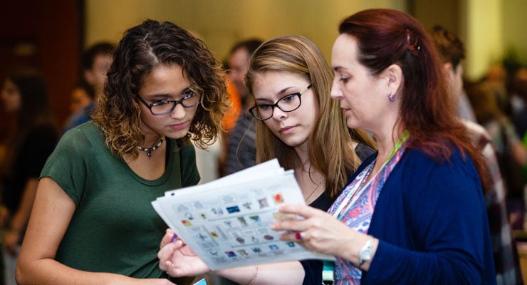 Students talking with a recruiter at a college.