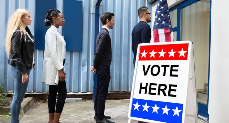 Four people standing in line to vote outside a polling location