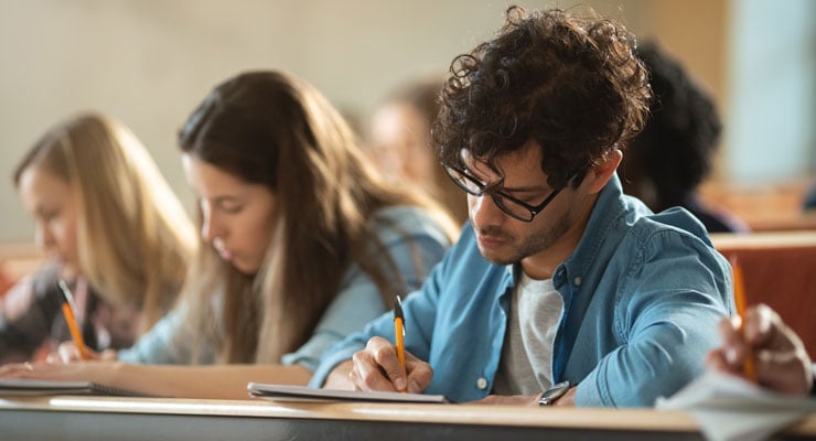 College students taking notes during a class lecture