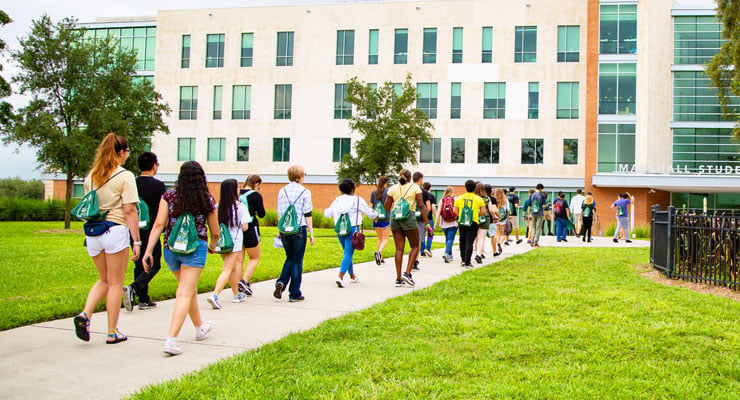 Prospective USF students and families take a campus tour and walk towards the Marshall Student Center.