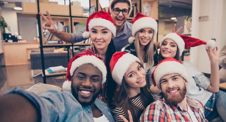 Group of college students in Santa hats celebrating Christmas on campus