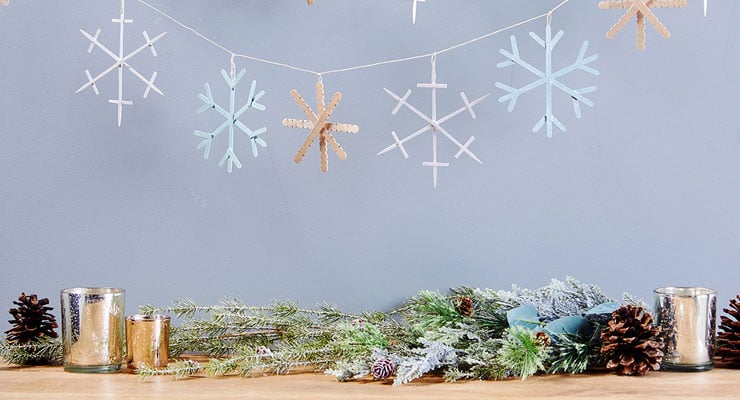 DIY snowflake garland on a string, holiday greens, pine cones and votive candles