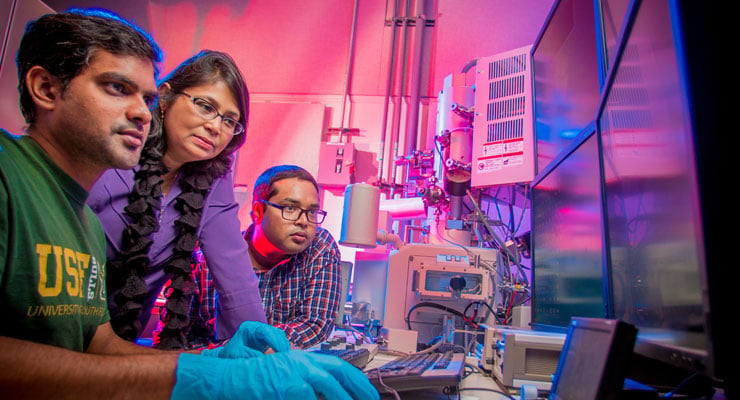 USF engineering students work with the professor in a lab.