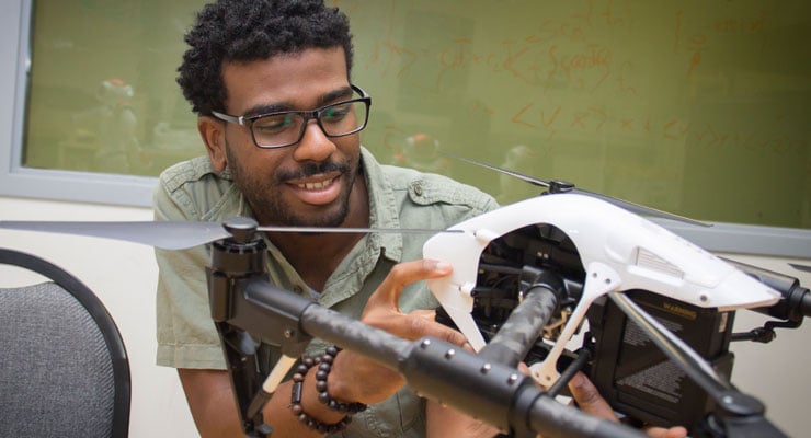 A USF engineering student works on a drone.