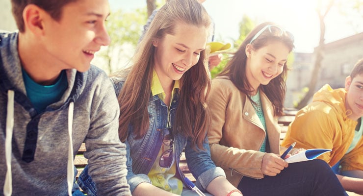 High school students study together outside at their high school.