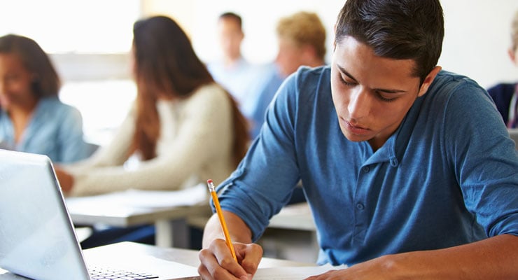 A high school student works hard on his homework to finish senior year strong.